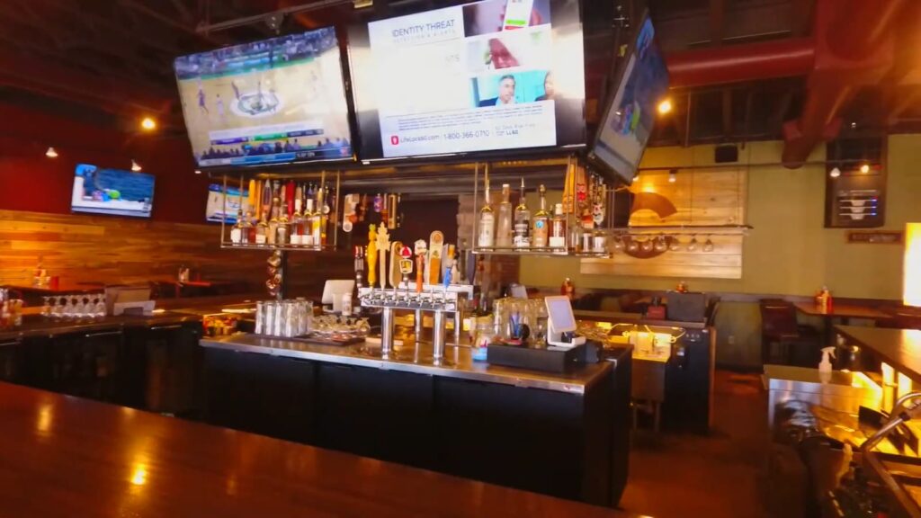 Interior of a bar with TVs and a variety of taps