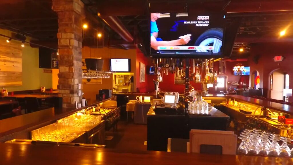 Bar interior with stone columns and a long row of taps