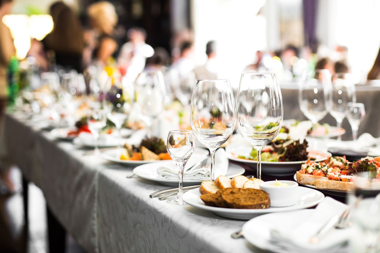 Sparkling glassware stands on long table with food